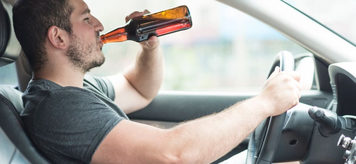 man-drinking-beer-car