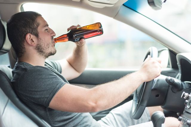 man-drinking-beer-car